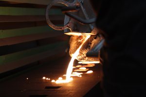 Iron molten metal pouring in sand mold ; green sand process